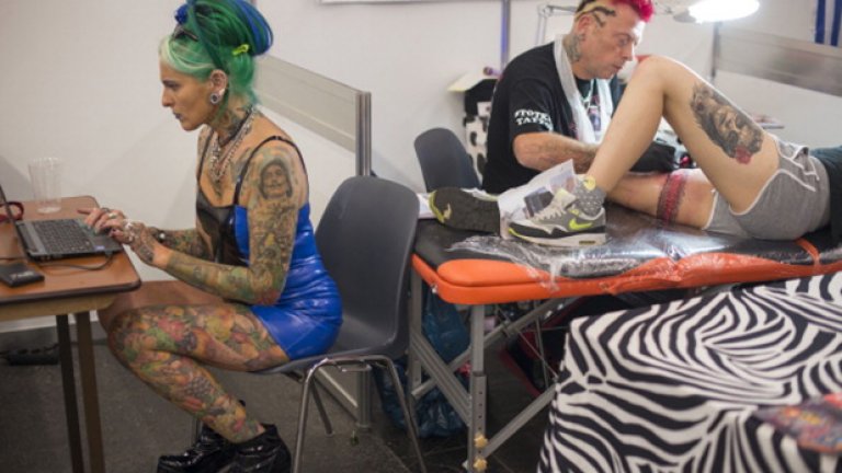 Художник татуира тялото на млада жена
