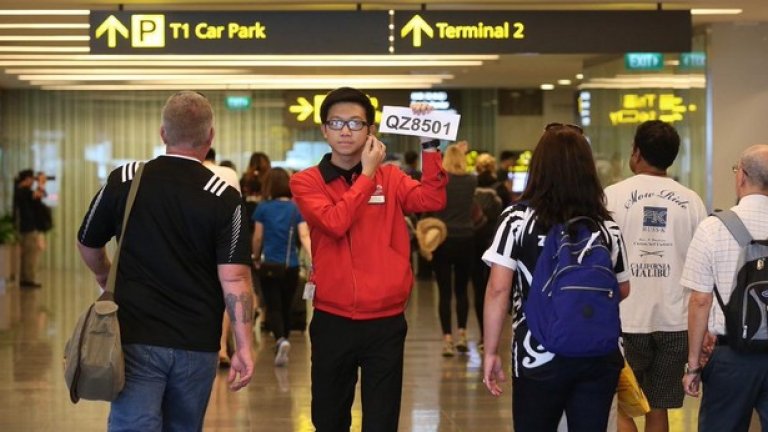 Служител на летището в Сингапур посочва на близките на пътниците къде могат да получат повече информация 