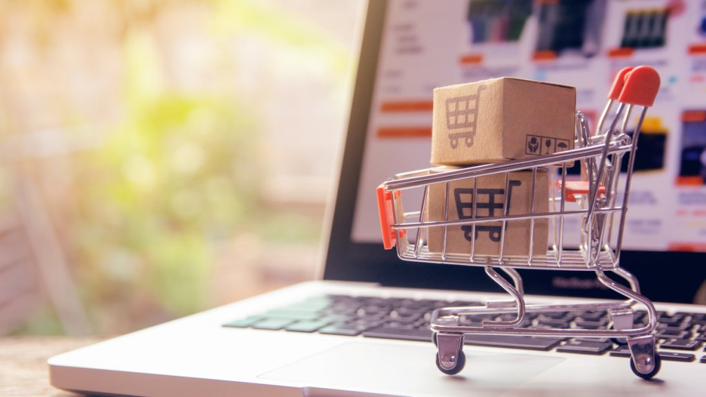 Shopping online concept - Parcel or Paper cartons with a shopping cart logo in a trolley on a laptop keyboard. Shopping service on The online web. offers home delivery.