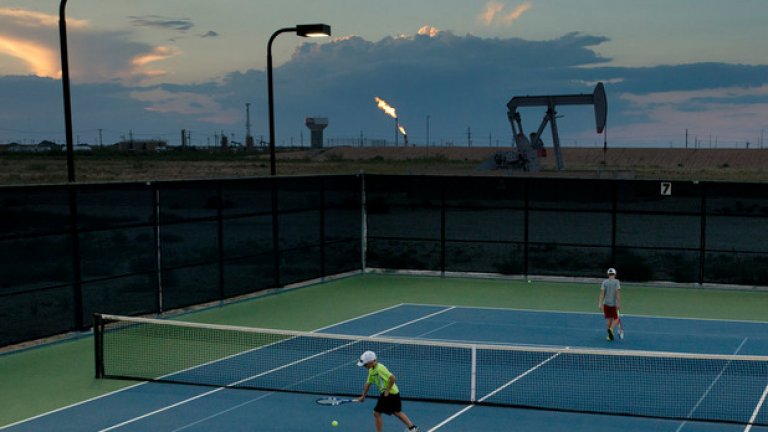 Комплекс "Буш тенис", построен с дарение от Джордж Буш. На заден план са петролните сонди и платформи, нещо типично за Тексас. Построени през 2012-а, тези 18 игрища приемат играчи срещу 6 долара за 90 минути тенис.