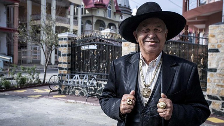 Мъж позира със златните си пръстени, ланец и зъби. В Бъзеску гражданите са принудени да демонстрират заможността си.