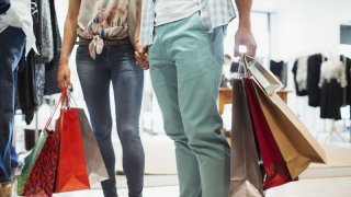 Couple carrying shopping bags in clothing store