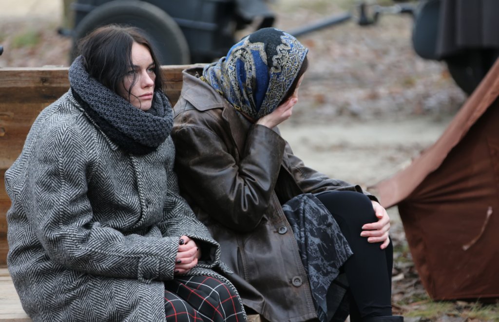 Tired women are sitting in the cold. Refugees. Refugees