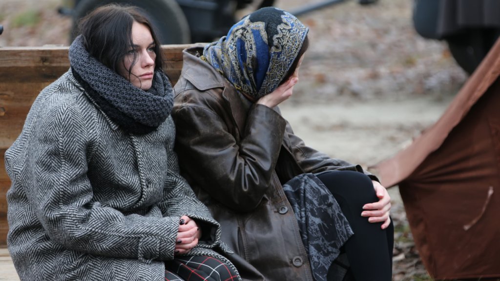 Tired women are sitting in the cold. Refugees. Refugees