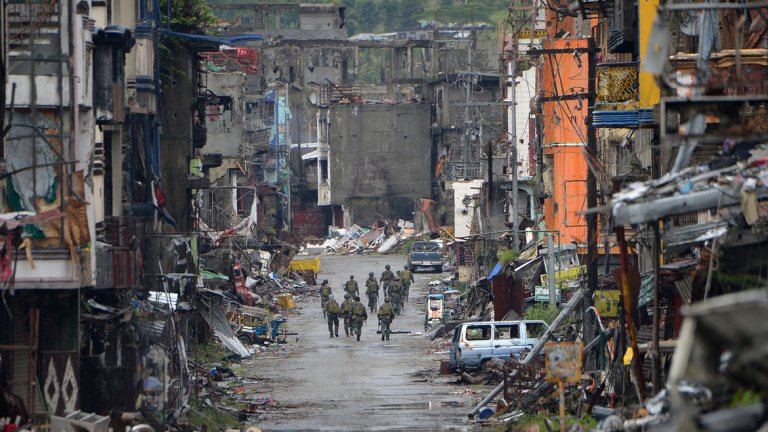 Филипински войници минават покрай унищожените сгради в района Банголо, след като президентът Дутерте обяви Марави за "освободен" на 17 октомври 2017 г.