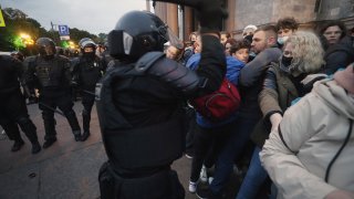 Най-много задържани има в Москва и Санкт Петербург (на снимките: полицаи и протестиращи в Санкт Петербург)