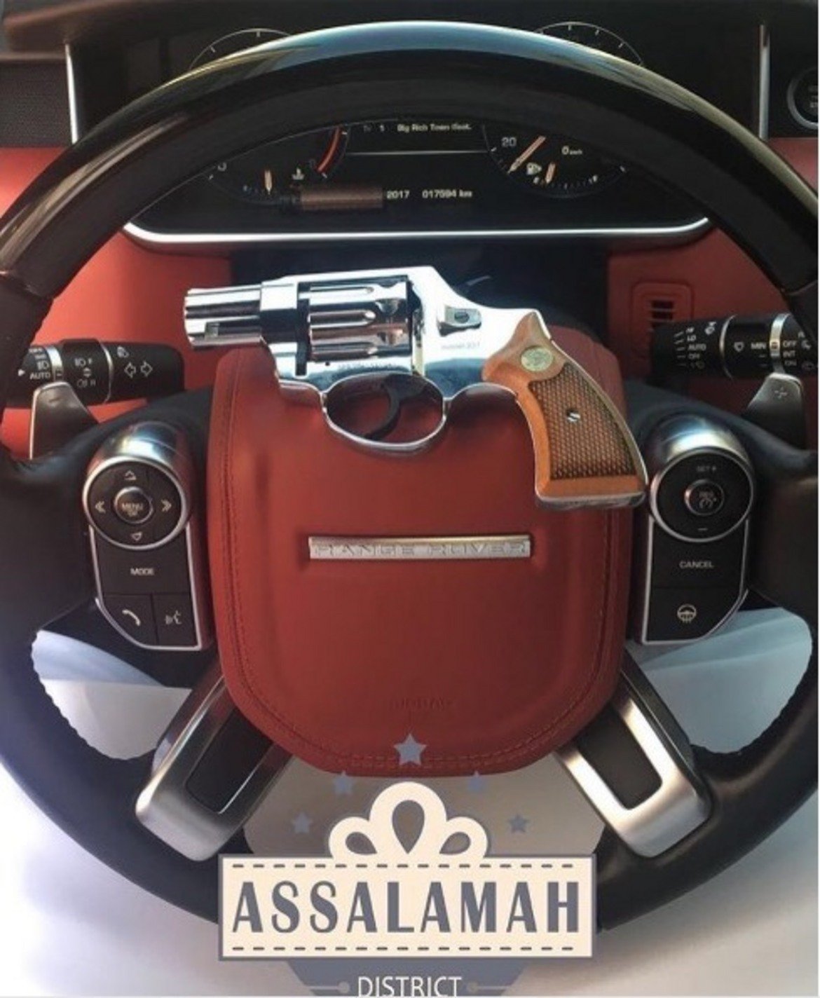 Сребърен револвер поставен върху волана на луксозен Range Rover