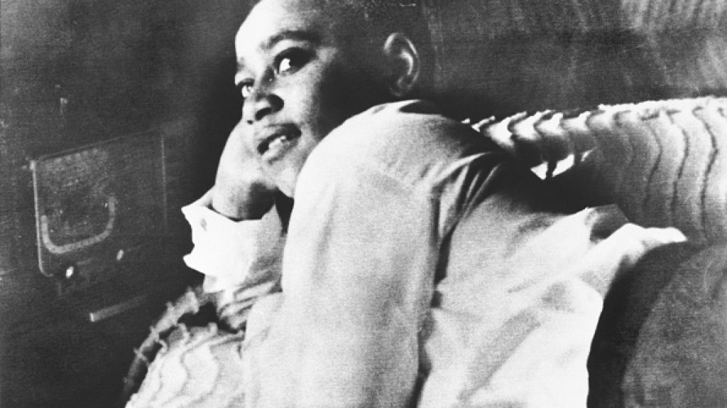 Emmett Till is shown lying on his bed.