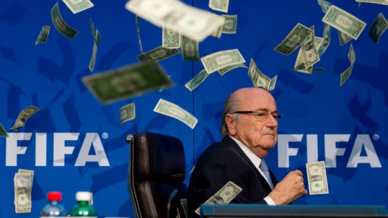Блатер сред летящи банкноти... каква символика. Британски комик направи номера на пресконференция на уличения в корупция шеф на ФИФА.