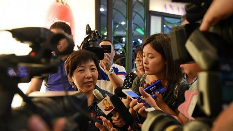 Близка на един от пътниците е заобиколена от журналисти, докато излиза от чакалнята на летището в Индонезия