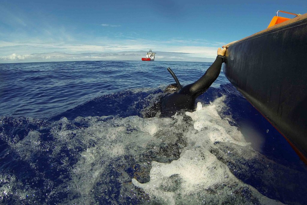 A fast response craft from Australian Defence Vessel Ocean Shield tows Able Seaman Clearance Diver Michael Arnold as he searches the ocean for debris of the missing Malaysian Airlines flight MH370