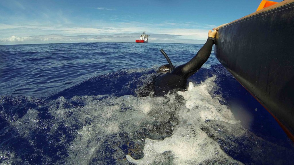 A fast response craft from Australian Defence Vessel Ocean Shield tows Able Seaman Clearance Diver Michael Arnold as he searches the ocean for debris of the missing Malaysian Airlines flight MH370