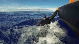 A fast response craft from Australian Defence Vessel Ocean Shield tows Able Seaman Clearance Diver Michael Arnold as he searches the ocean for debris of the missing Malaysian Airlines flight MH370