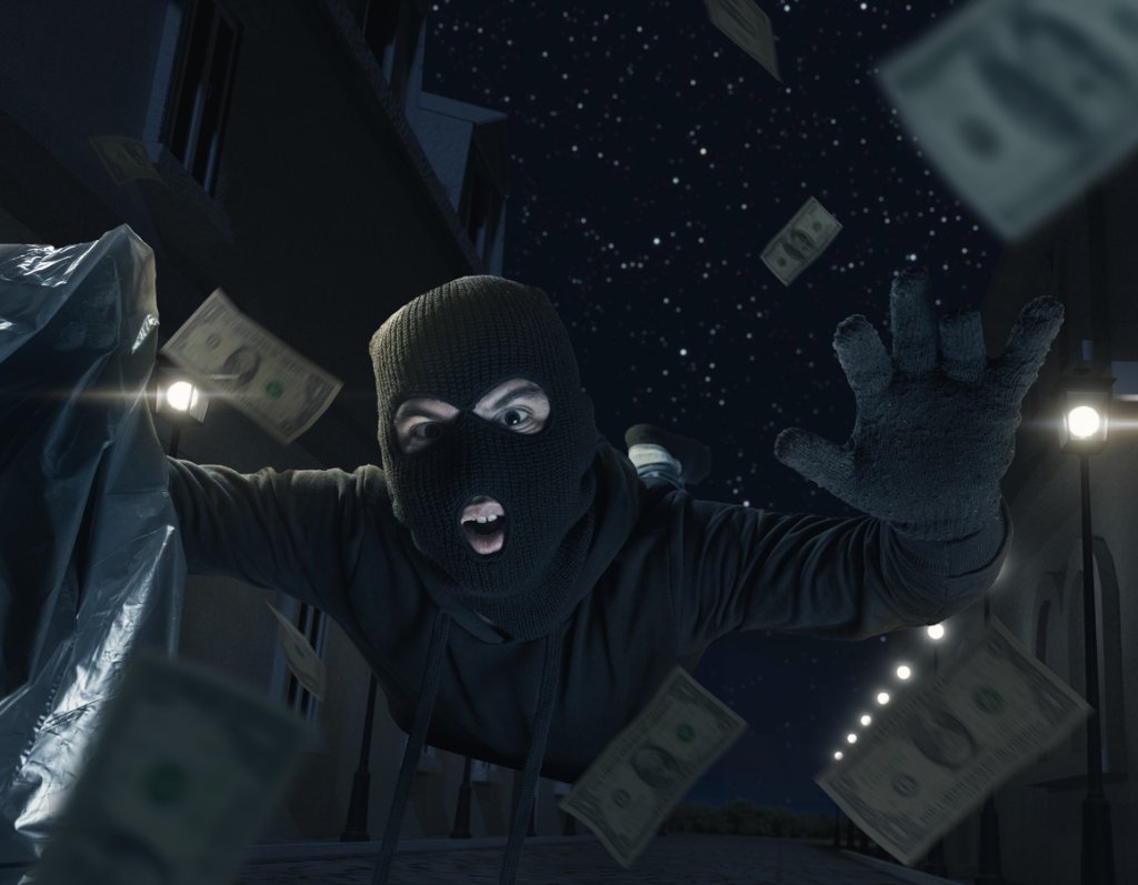 thief with balaclava and moneybag slipping and falling on the street