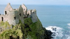 Величествените стени на северноирландския Dunluce Castle могат да се видят при еднодневна екскурзия от Белфаст или от Дъблин