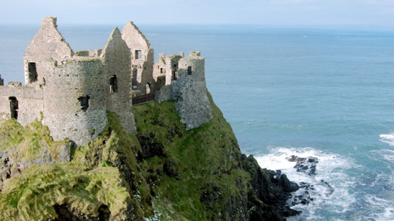 Величествените стени на северноирландския Dunluce Castle могат да се видят при еднодневна екскурзия от Белфаст или от Дъблин