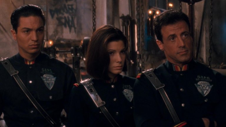 "Разрушителят" (1993 г.)
Добре, че в екшън-фантастиката със Силвестър Сталоун, Уесли Снайпс и Сандра Бълок не познават за трите миди, но пък знае ли човек какво ще се случи с тоалетните навици на човечеството? Това, което сценаристите нацелват обаче, е идеята за социална дистанция.
Действието на филма се развива през 2032 година, когато светът се възстановява от разпространението на няколко вирусни епидемии и по тази причина е забранен всякакъв физически контакт, а хората използват видеоразговори, когато общуват от разстояние. Горе-долу както ние правехме доскоро.