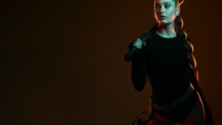 Warrior, woman and sword with space in studio for action, fight and safety from danger. Strong female vigilante, assassin or agent in scifi cosplay costume with weapon for mockup dark background
