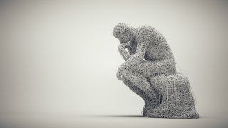 Thoughtful man sitting down. Confusion and overthinking concept.