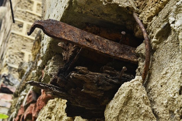 Метална скоба, която някога е придържала дървените греди на покрива, стърчи от изтърбушената стена