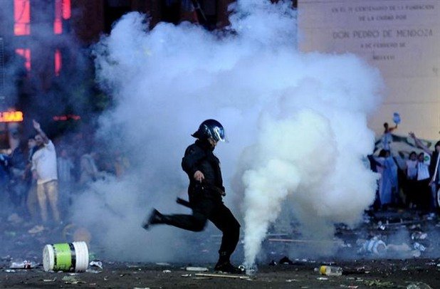 Полицай изритва димка, хвърлена от ултрасите.