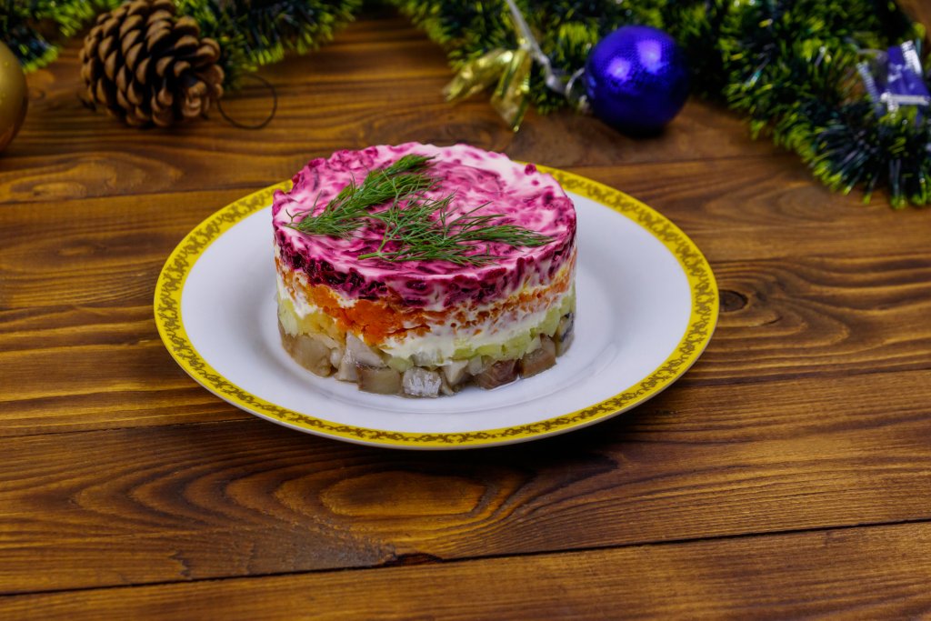 Сельодка под шубаСалата, предястие или интересно основно ястие – вие решете как ще сервирате сельодката под шуба. За нея ви трябват две големи филета сельодка в собствен сос, които режете на не много ситни кубчета и нареждате на дъното на ринг за оформяне. Ръсите с червен лук, нарязан на ситно. Следващият пласт е от настъргани варени картофи с майонеза и накрая – сварено до пълно омекване червено цвекло с майонеза.
Приберете сельодката под шуба в хладилника за поне 2-3 часа, а най-добре е да я оставите цяла нощ, за да стегне добре във формата и да си попие вкусовете. Сервирайте добре охладена с чаша водка или ледено бяло вино.