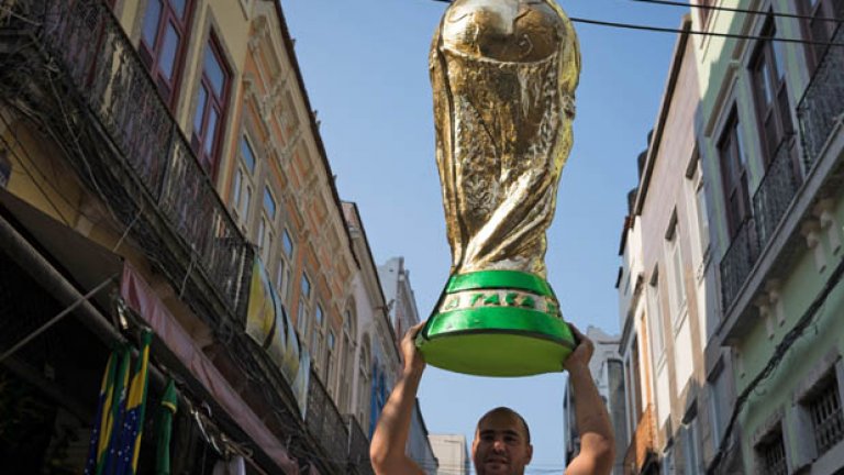Търговец разнася по улиците огромна реплика на световната купа, каквито ще видим много по стадионите.