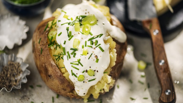 Пълнен картоф с фета и сметанаТова е една малко по-лека и свежа рецепта за пълнени картофи. За всяка порция ни трябва по един голям картоф – изпечен, разрязан и с намачкана леко вътрешност. За пълнежа смесваме 50 грама фета (или друго прясно сирене) и 50 грама заквасена сметана, подправяме със сол, пипер и зелени подправки по избор – магданоз, риган, зелен лук. Разбъркваме добре, пълним картофа и го поднасяме веднага.