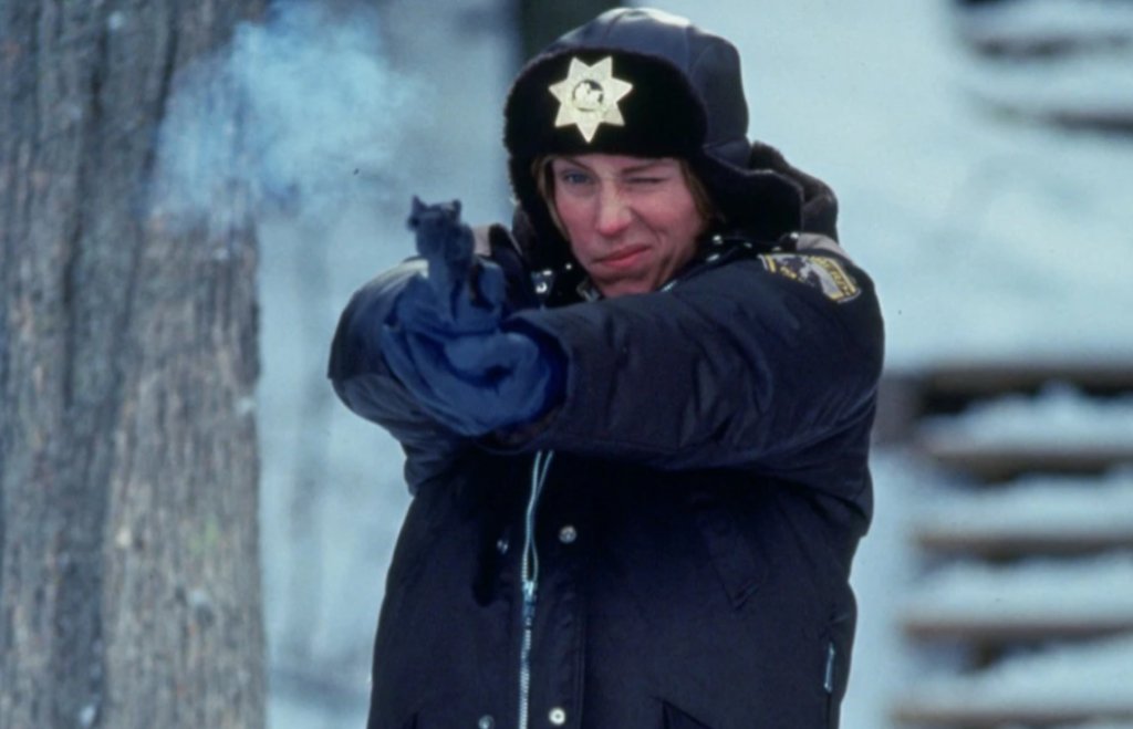 8. “Фарго” (1996 г.)
Криминалната черна комедия, режисирана от братята Коен, разказва историята на отчаян автомобилен търговец от Минесота, който замисля да инсценира отвличането на собствената си съпруга, за да иска откуп от богатия ѝ баща. Но планът излиза извън контрол, когато разследването е поето от упоритата полицайка Мардж Гъндерсън.