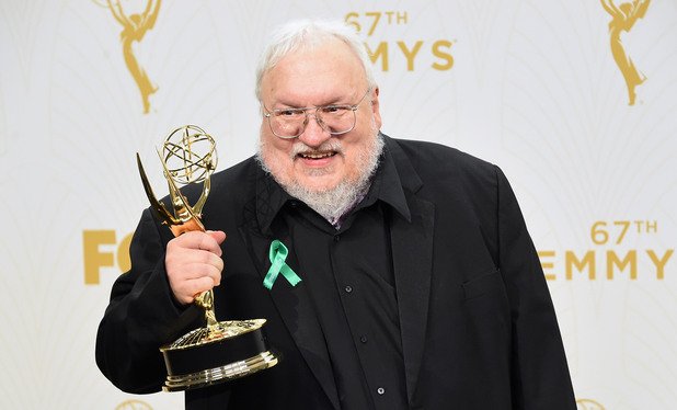 Авторът на поредицата "Песен за огън и лед" Джордж Р. Р. Мартин държи спечелената от Game of Thrones статуетка за най-добър драматичен сериал