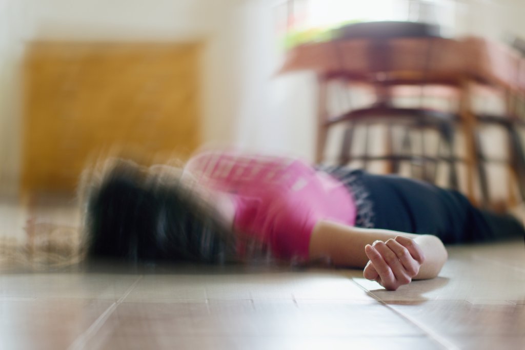 Woman lying on the floor at home, epilepsy, unconsciousness, faint, stroke, accident or other health problem.