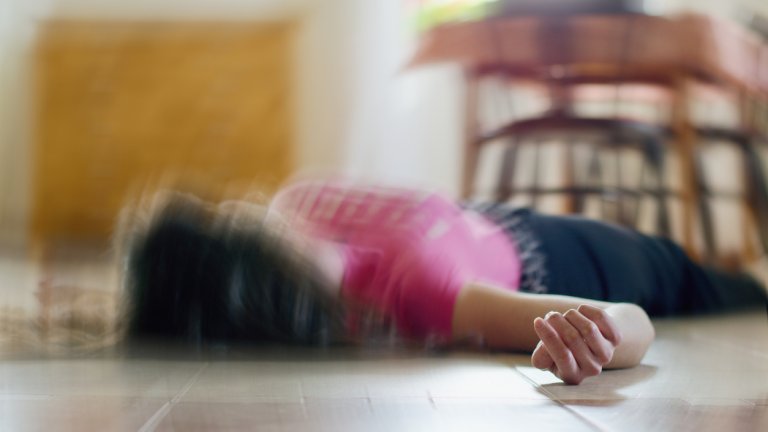 Woman lying on the floor at home, epilepsy, unconsciousness, faint, stroke, accident or other health problem.