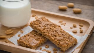 Granola bars on wooden plate and glass of milk