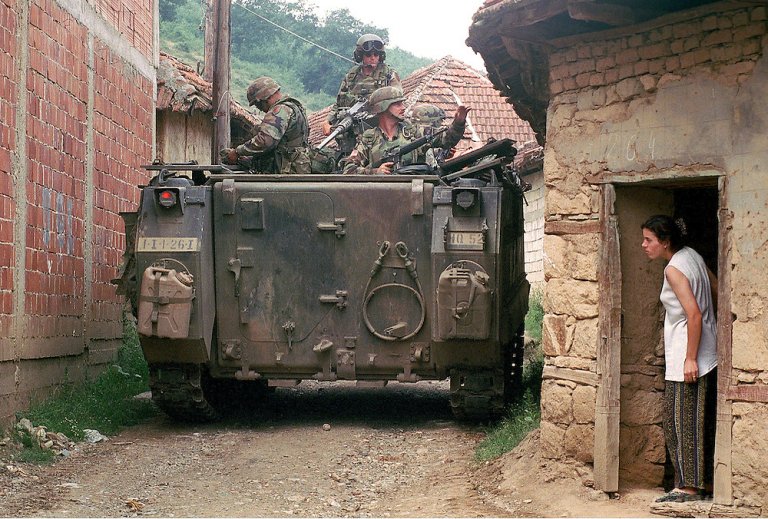 Една от първите професионални снимки на Ейми Витале. На кадъра етническа албанка гледа влизането на американската армия в селото ѝ. Снимката е направена на 2 август 1999 г.