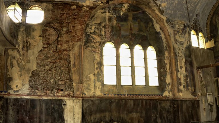 Бръшлянът, растящ по фасадата, прониква през тухлите и събаря мазилката, унищожавайки стенописите, които са изрисувани върху нея