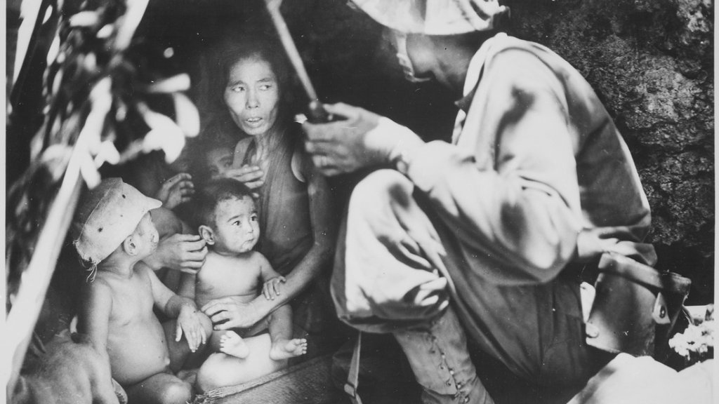 _A_member_of_a_Marine_patrol_on_Saipan_found_this_family_of_Japs_hiding_in_a_hillside_cave._The_mother,_four_children_an_-_NARA_-_532380.tif