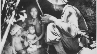 _A_member_of_a_Marine_patrol_on_Saipan_found_this_family_of_Japs_hiding_in_a_hillside_cave._The_mother,_four_children_an_-_NARA_-_532380.tif