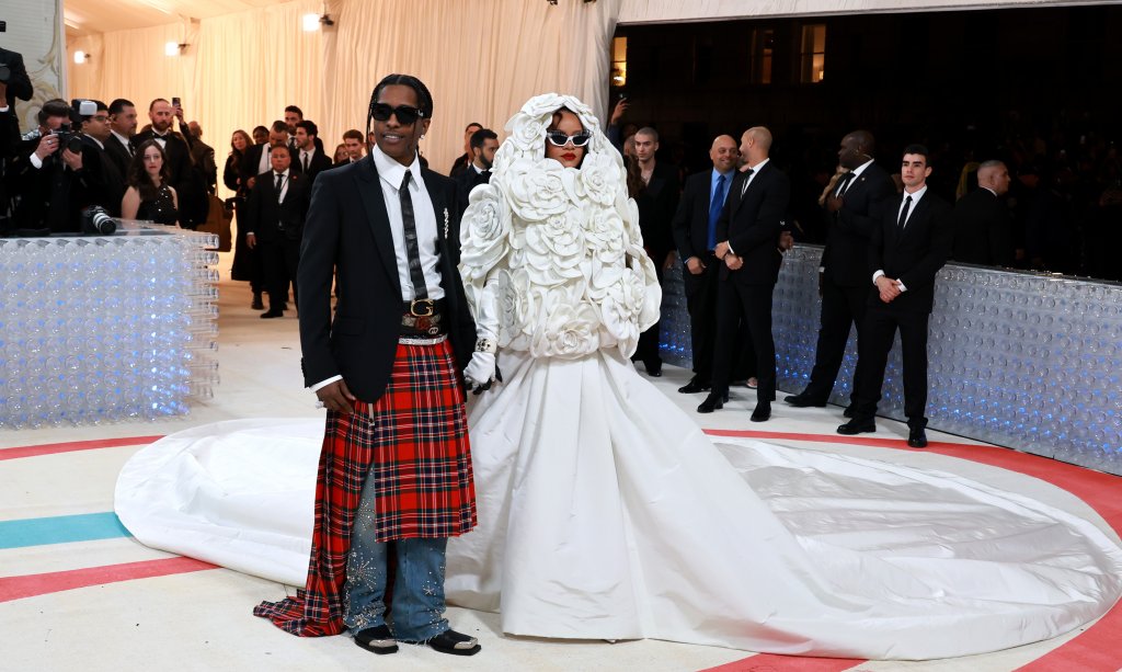Риана и ASAP Rocky
Кралицата на модния стил - Риана, облече рокля на Valentino, която интерпретираше един от най-известните костюми на Chanel - в бял цвят и акцент от камелии. Половинката на изпълнителката ASAP Rocky се облече в костюм, който Лагерфелд е носил приживе - черно сако, бяла риза и шотландски килт.