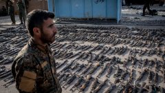 Войник на Сирийските демократични сили (SDF) пред иззето от "Ислямска държава" оръжие в Бангуз, Сирия.
