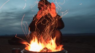 man-sitting-facing-fire-in-pot-during-night-2422968