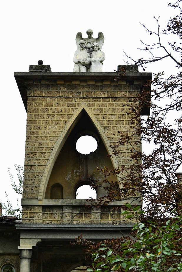 Кулата над централния вход, заедно със скулптурната композиция “Ангелът със старецът и старицата”, изработена от чешкият майстор Йосиф Шквара