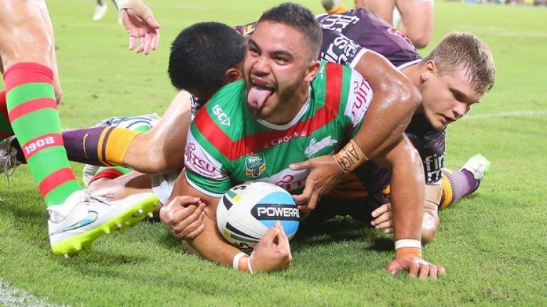 Дилан Уокър от Южен Сидни е стигнал зад крайната линия и бележи точки за своя тим в мача по ръгби срещу Брисбейн и се плези палаво, независимо от здравата преса на двама съперници. Собственик на Южен Сидни е звездата от Холивуд Ръсел Кроу.