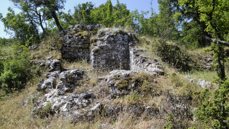 Платовидният връх е изцяло покрит с треви, сред които тук-там се белеят камъните от старинните зидове.