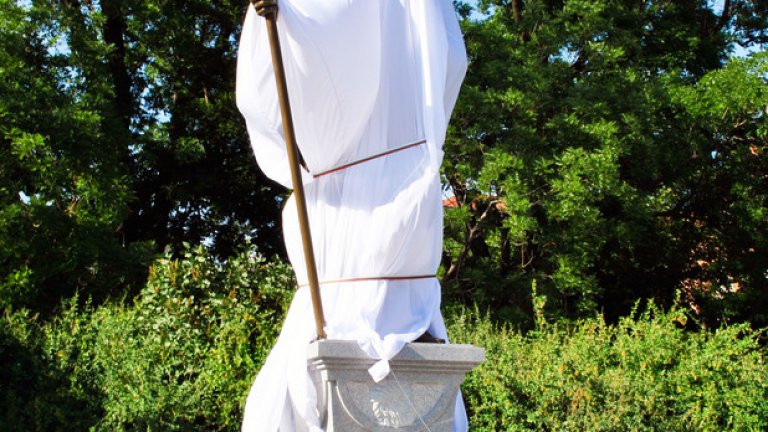 Покритият монумент предизвиква вниманието на преминаващите хора