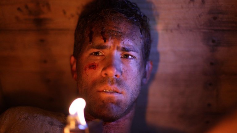 4. Buried / Погребан
Реж. Родриго Кортес, 2010 г.
Райън Рейнолдс играе Пол Конрой - американец, който работи в Ирак. След като конвоят му е нападнат, той се оказва заровен в дървена ковчег. Посредством оставен в ковчега телефон, Конрой комуникира с човека, който го е отвлякъл, с полицията, с държавния департамент и няколко други персонажи - всичко това в опит да намери начин да бъде открит и измъкнат преди въздухът му да свърши и да умре, заровен и забравен. Цялото действие на този трилър се развива в ограниченото пространство на дървената кутия, осветена в различни цветове от дисплея на телефона, едно фенерче и запалка, а Райън Рейнолдс се справя достатъчно добре, за да задържи вниманието ви.