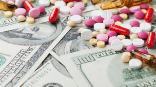 cost medicinal product and treatment concept, pills tablets with cash