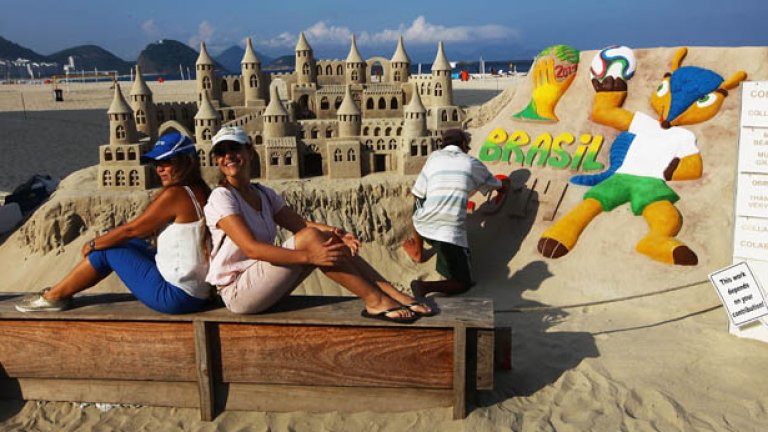 На плажа Копакабана творци създават емблеми и талисмани на световното в пясъка, а и "рекламата" на творбата хваща окото - местни момичета позират край автора.