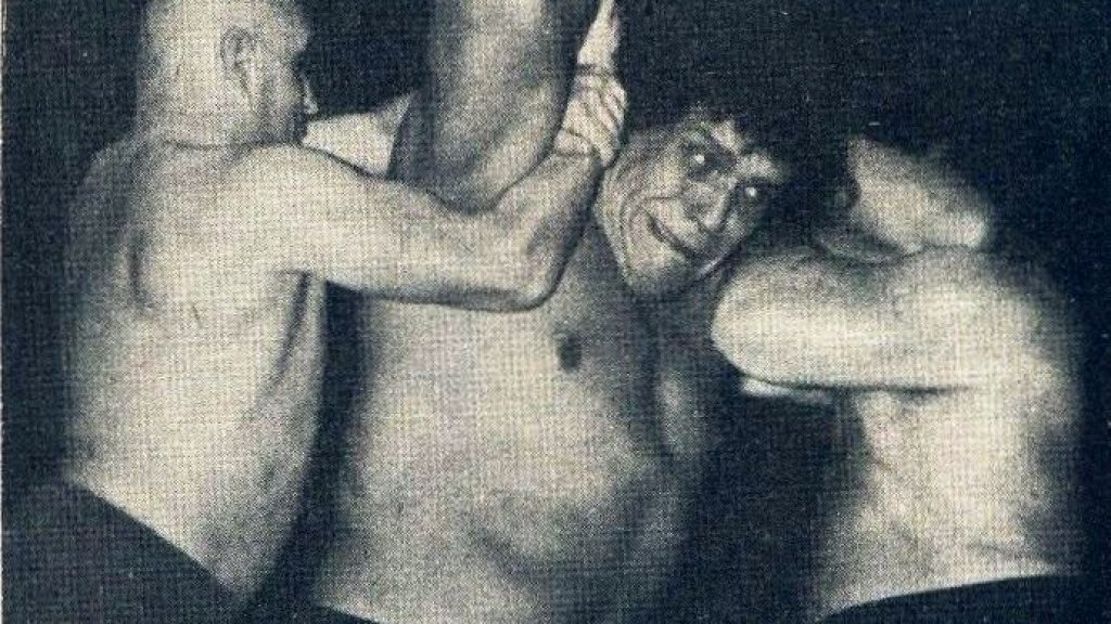 Le_Géant_Ferré_being_hold_by_two_wrestlers_-_Wrestling_Revue_June_1973_page_14_-_André_the_Giant_-_Unwanted_by_my_family,_I_left_home_at_fourteen_(cropped)