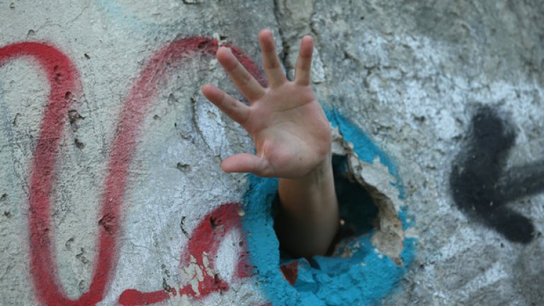 Турист провира ръката си през дупка в Стената