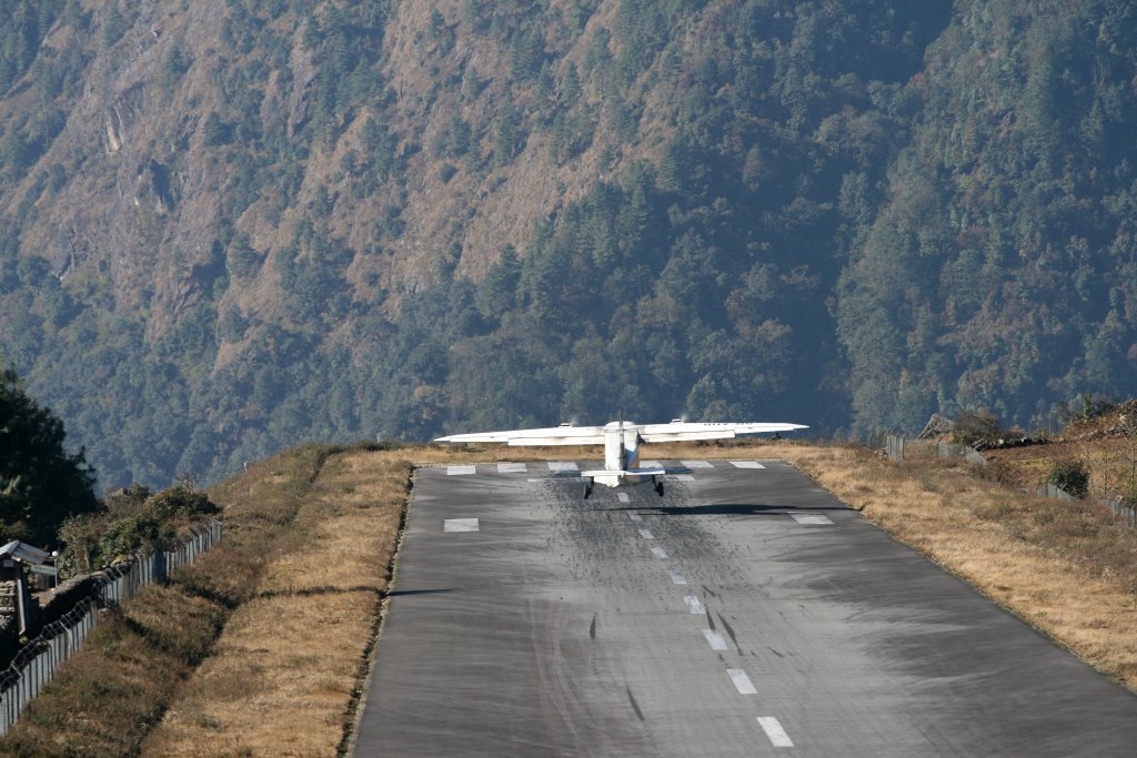 Лукла, Непал
Често е наричано най-опасното летище на света и предлага планини, вятър и къса писта. То е вратата към Еверест, в Хималаите, а пистата свършва в пропаст. За да помогне на самолетите да намалят скоростта, пистата дори е повдигната. Няма и вариант за обикаляне при отказ от кацане, за издигане и нов заход. Ако самолетът е на края на спускането към земята, трябва да кацне. Е, гледките към Хималаите поне са изумителни.